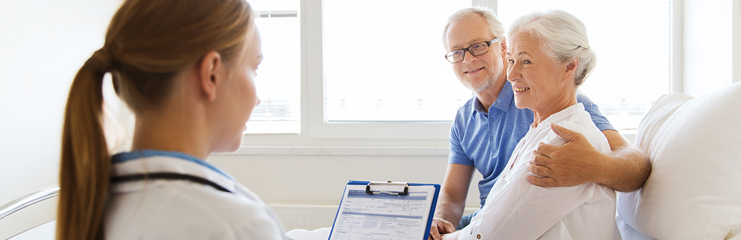 senior couple talking with doctor